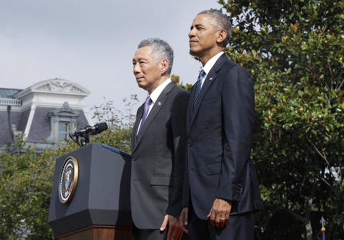 President Barack Obama and Singapore's Prime Minister Lee Hsien Loong stand and watch a state arrival ceremony on the South Lawn of the White House in Washington Tuesday Aug. 2 2016