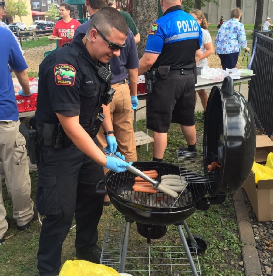 Officer Burg works the grill at National Night Out in Cameron Park on Tuesday