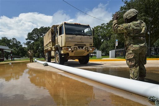 Members of the Louisiana Army National Guard help place sandbags to protect the city hall in Lake Arthur La. Wednesday Aug. 17 2016