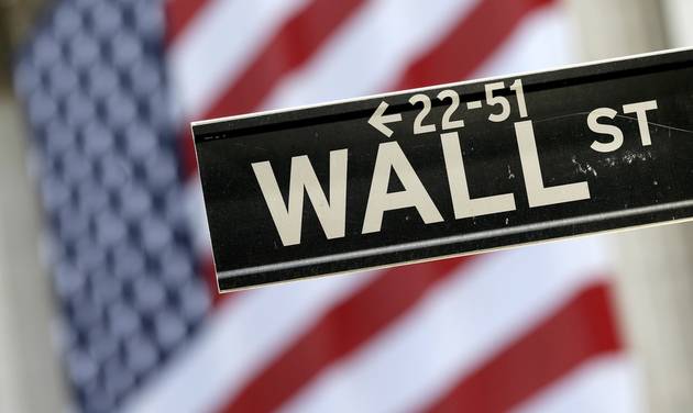 Wall Street street sign is framed by an American flag hanging on the facade of the New York Stock Exchange. Global stock markets rose Tuesday Aug. 9 2016 as slack Chinese consumer price figures stoke