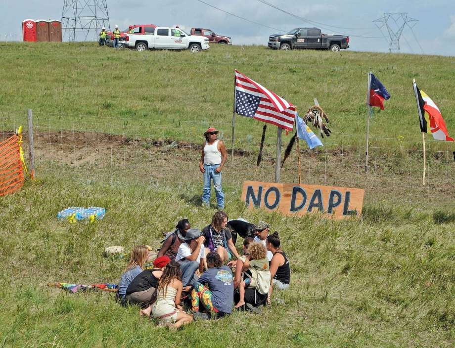 Bill Left Hand of McLaughlin S.D. stands next to a sign at the site of a protest Friday Aug. 12 2016 against construction of the Dakota Access Pipeline that will cross the Missouri River in Morton County. The pipeline would start in North Dakota and