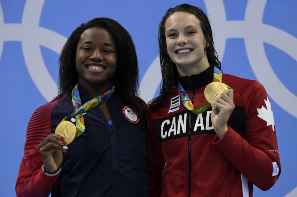 USA's Simone Manuel left and Canada's Penny Oleksiak pose on the podium after tying for gold in the women's 100m freestyle at the Rio 2016 Olympic Games on Thursday