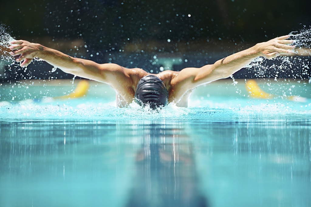 Shot of a male swimmer doing the butterfly stroke toward the camera