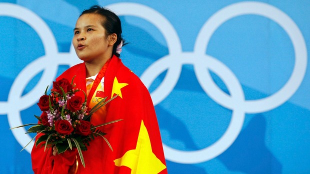 Chen Xiexia of China sings the national anthem after receiving her gold medal for the women's 48kg Group A weightlifting