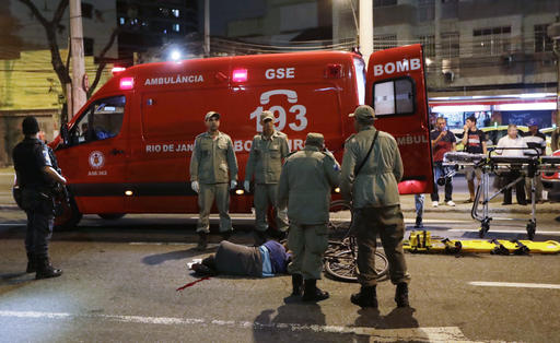 Officials stand near the body of a man that was shot and killed near Maracana Stadium after the opening ceremony at the 2016 Summer Olympics in Rio de Janeiro Brazil Saturday Aug. 6 2016