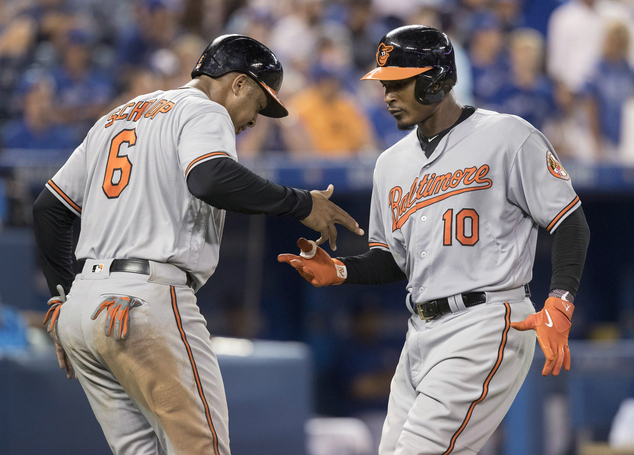 Baltimore Orioles Jonathan Schoop left congratulates Adam Jones after Jones hit a three-run home run against the Toronto Blue Jays during the 12th inning