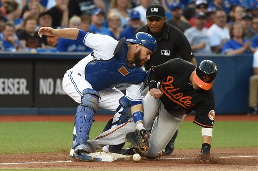 Toronto Blue Jays Russell Martin drops the ball missing the tag on Baltimore Orioles Manny Machado at third during the third inning of a baseball game Friday