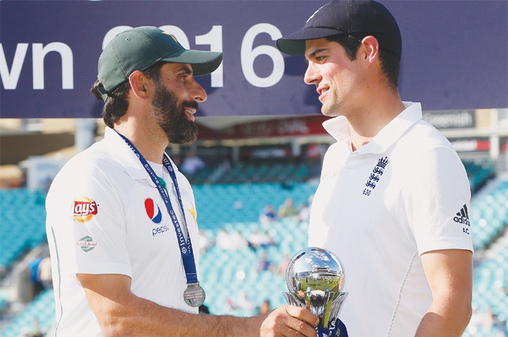 PAKISTAN captain Misbah-ul Haq and his England counterpart Alastair Cook in conversation while holding the trophy.—Reuters