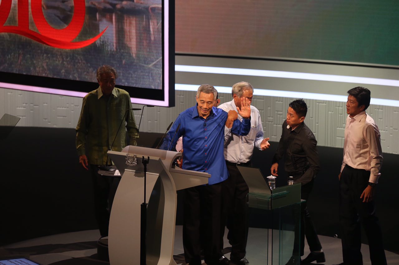 PM Lee waves to the audience as he is helped off the stage. ST