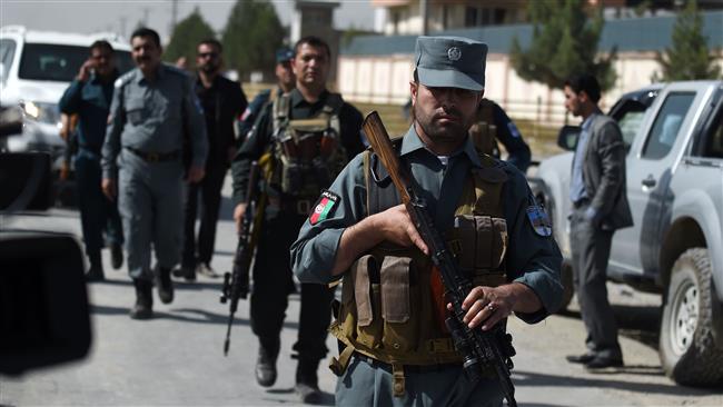 Afghan security personnel walk after a powerful truck bomb targeting a hotel used by foreign contractors exploded on the outskirts of Kabul