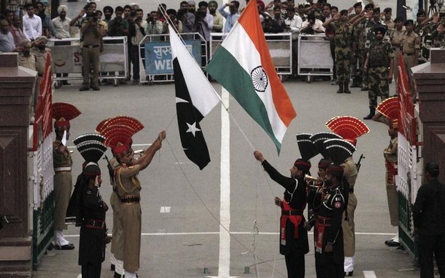 Pakistani rangers and Indian Border Security Force officers lower their national flags during a daily parade at the Pakistan India joint check-post at Wagah border near Lahore