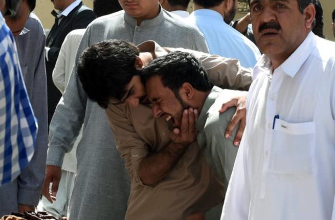 Pakistani journalists grieve over the body of a news cameraman after an explosion at a government hospital in Quetta on Monday