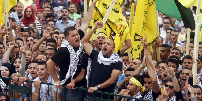 Palestinian supporters of the Fatah movement attend a rally on the outskirts of the West Bank city of Ramallah