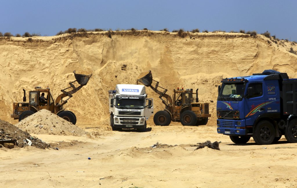 Palestinian diggers dump sand into a truck at the site of Al Isra 2 housing project in Khan Younis Gaza Strip where Jewish communities thrived until 2005. Hamas has begun handing out plots of public land to 40,000 civil servants loyal to it. (AP