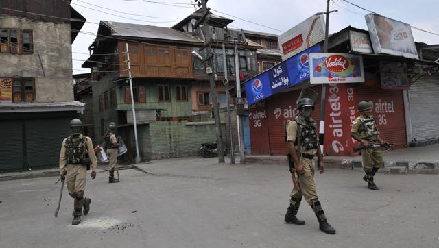 Paramilitary soldiers stand guard during curfew in downtown area of Srinagar