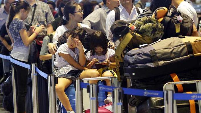 Passengers line up at check-in counter for Delta Air Lines at Narita international airport Tokyo Tuesday Aug. 9 2016