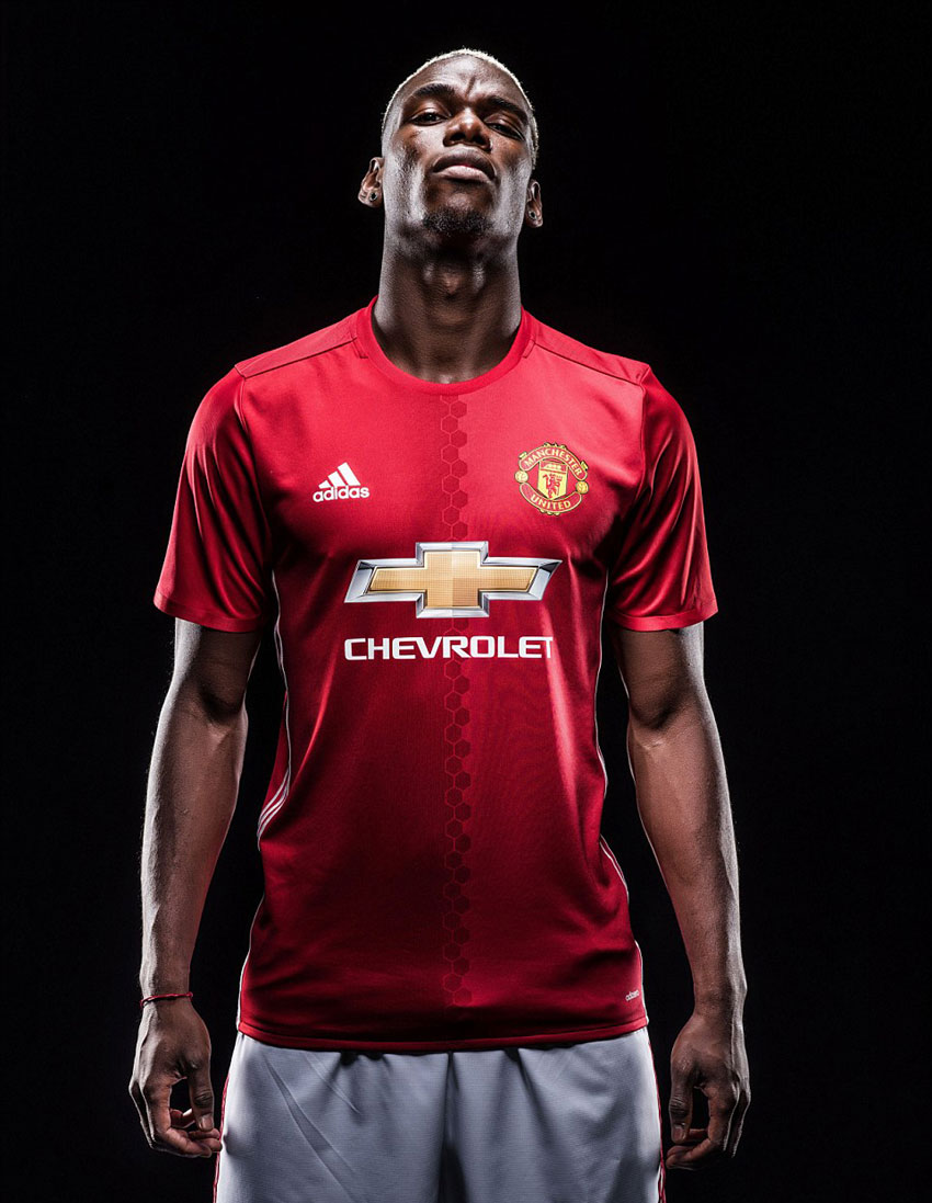 Paul Pogba poses with the Manchester United kit after completing his record transfer