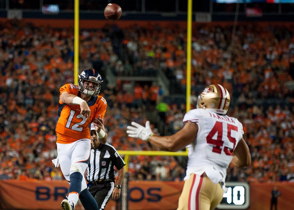 DENVER CO- AUGUST 20 Quarterback Paxton Lynch #12 of the Denver Broncos passes for a third quarter touchdown under coverage by linebacker Jason Fanaika #45 of the San Francisco 49ers during a preseason NFL game at Sports Authority Field at Mile High