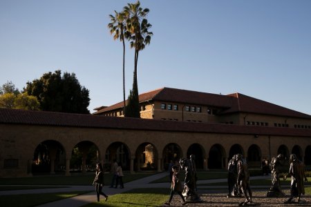 Pedestrians walk past a group of statues at Stanford University in Stanford California