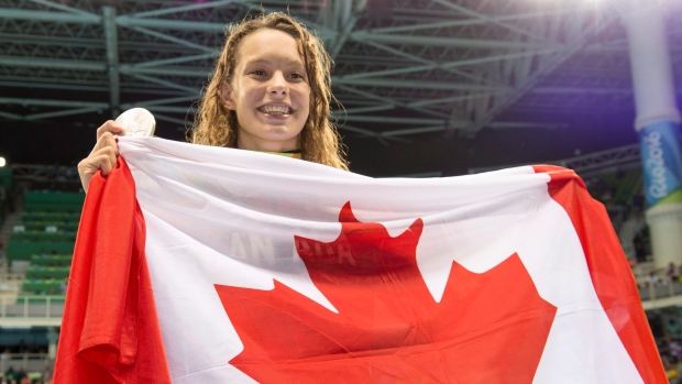 Penny Oleksiak shows off her silver medal from the women's 100-metre butterfly on Sunday