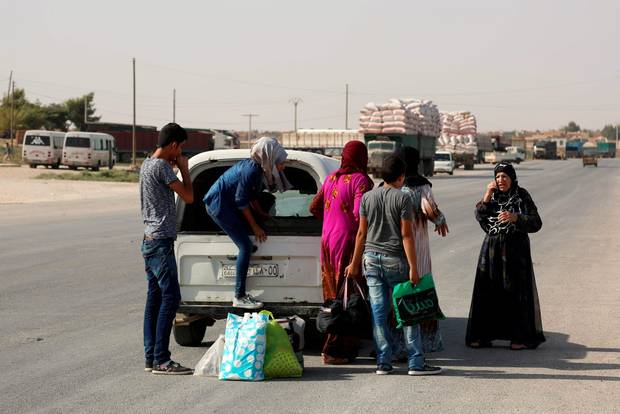 Syrian Kurdish civilians flee reported shelling in the northeastern governorate of Hasakah toward the city of Qameshli