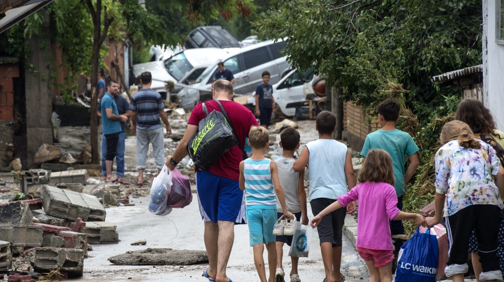 People leave their flood hit homes in the village of Stajkovci Skopje