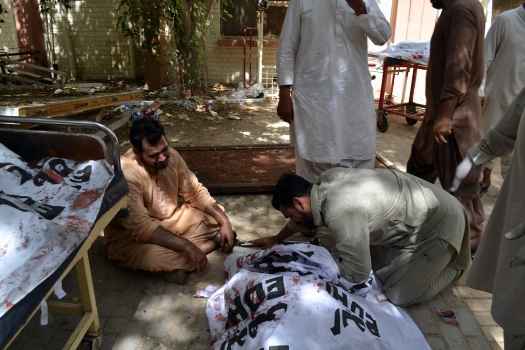 People mourn over a dead body at the blast site in Quetta southwest Pakistan Aug. 8 2016