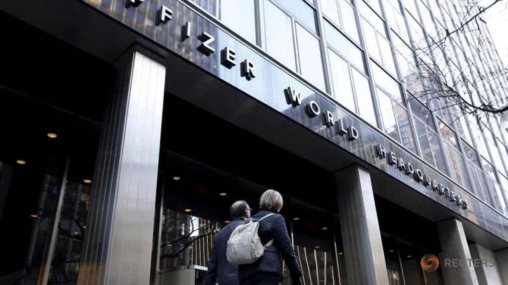 People pass the Pfizer World Headquarters building in New York