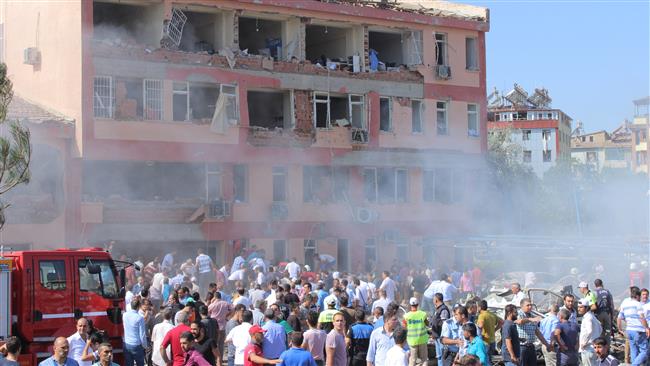 People rush to the blast scene after a car bomb attack on a police station in Elazig Turkey