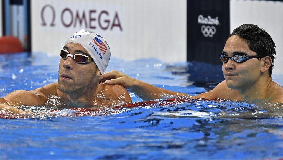 Michael Phelps and Singapore's Joseph Schooling check their times after a men's 100-meter butterfly heat during the swimming competitions at the 2016 Summer Olympics Thursday Aug. 11 2016 in Rio de Janeiro Brazil