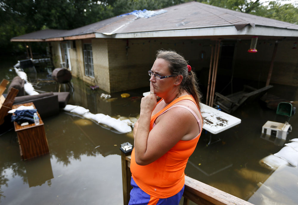 Amber James stands outside her mother's flooded home in St. Amant Louisiana U.S