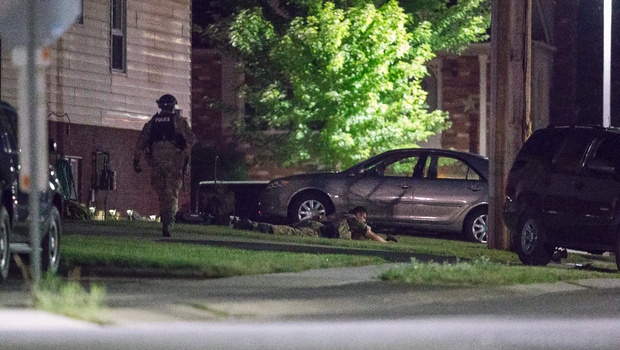 Police keep watch around a house in Strathroy Ontario Wednesday