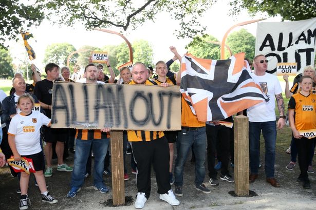 Plumb Images
Fans outside the ground with signs against the owners Ehab and Assem Allam