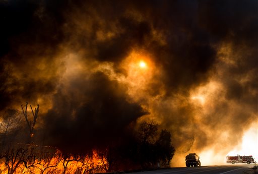 Firefighters battle a wildfire as it crosses Cajon Boulevard in Keenbrook Calif. on Wednesday Aug. 17 2016. Firefighters had at least established a foothold of control of the blaze the day after it broke out for unknown reasons in the Cajon Pass near