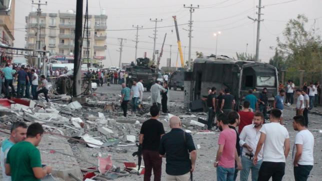 Police and officials surround the scene of a bomb blast in Kiziltepe Turkey