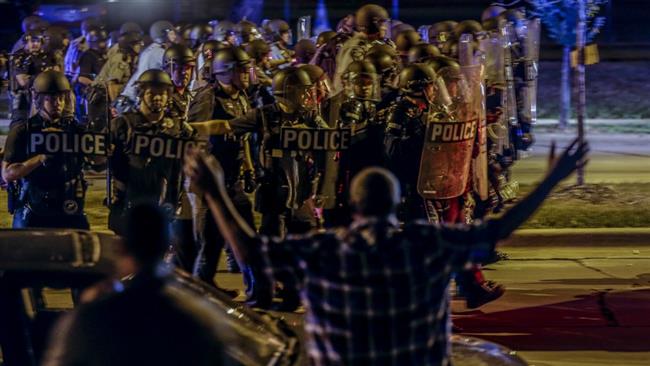 Police approach a group of protesters throwing rocks at them on Sunday night