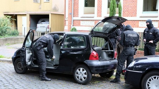 Police inspectors search a car