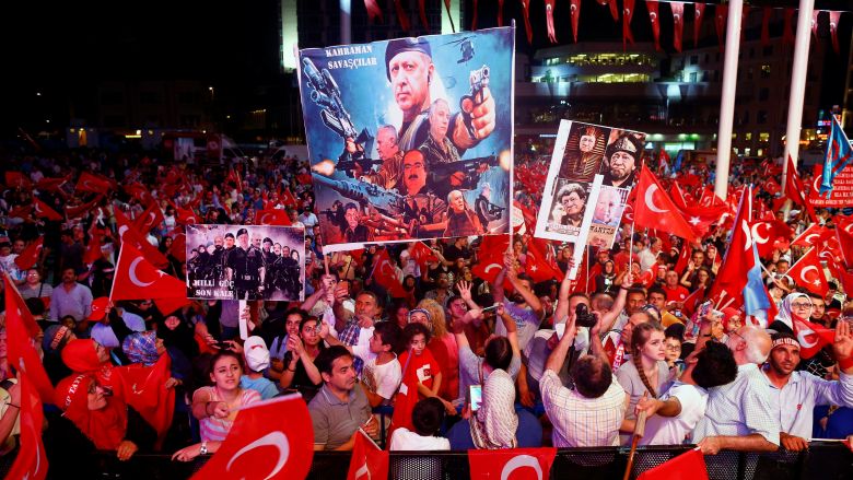 Supporters of Turkish President Recep Tayyip Erdogan wave national flags as they listen to him through a giant screen in Istanbul's Taksim Square Turkey