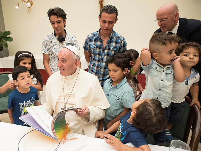 Pope Francis sits with some Syrian refugees at the Vatican on Aug. 11 2016