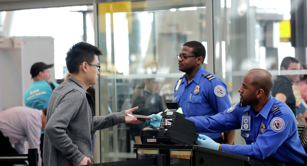 A traveler left hands his documents to a Transportation Security Administration officer as part of security screening at John F. Kennedy International Airport