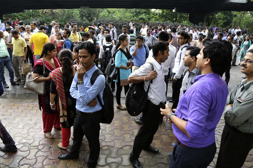 People stand outdoors after they rushed out of their offices following tremors in Kolkata India Wednesday Aug. 24 2016. A powerful earthquake with a preliminary magnitude of 6.8 shook central Myanmar on Wednesday knocking glasses off tables and sendi