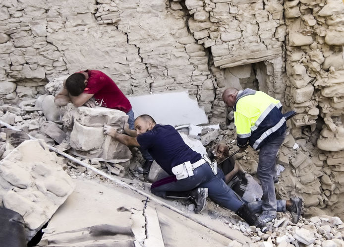 A man cries as rescuers help an injured survivor Wednesday in Amatrice Italy where an earthquake struck just after 3:30 a.m