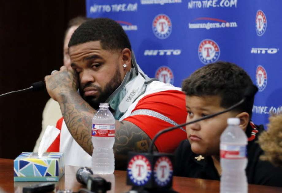 Texas Rangers Prince Fielder left wipes his eyes as he sits by his son Haven during a news conference before a baseball game against the Colorado Rockies Wednesday Aug. 10 2016 in Arlington Texas. The 32-year-old slugger won't play baseball again