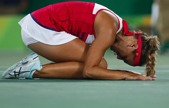 Monica Puig of Puerto Rico kneels on the court after winning the gold medal match in the women's tennis competition at the 2016 Summer Olympics in Rio de Janeiro Brazil Saturday Aug. 13 2016