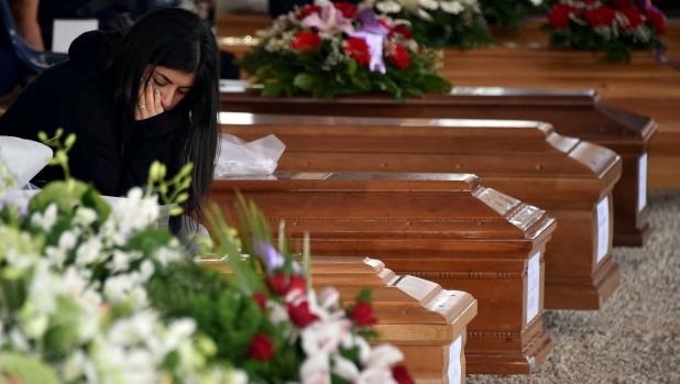 A mourner pays her respects prior to a funeral service for victims of the earthquake that levelled the town in Amatrice