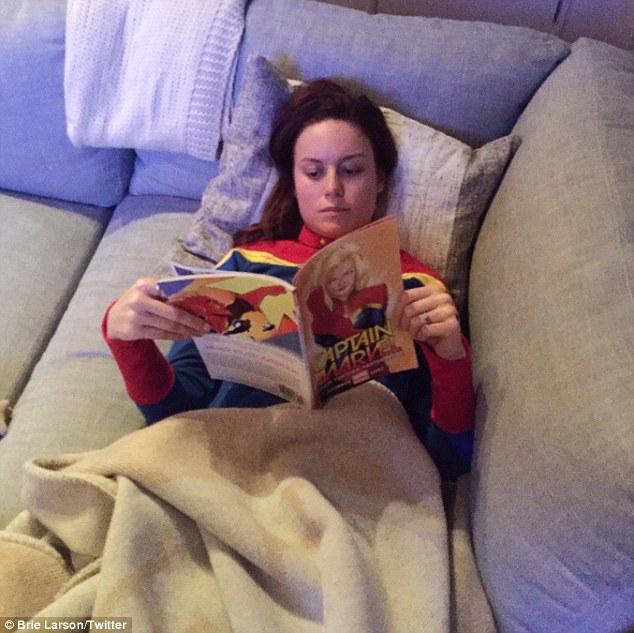 R&D department! Brie Larson reads Captain Marvel in bed... while dressed as superhero