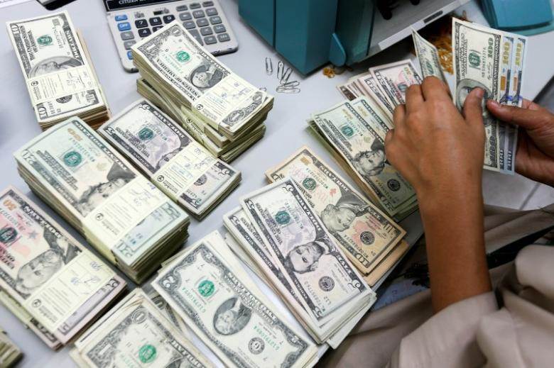 A bank employee counts U.S. dollar notes at a Kasikornbank in Bangkok