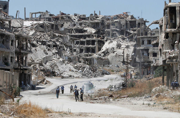 Workers collect the rubble of damaged buildings to be recycled and reused for reconstruction in Homs Syria