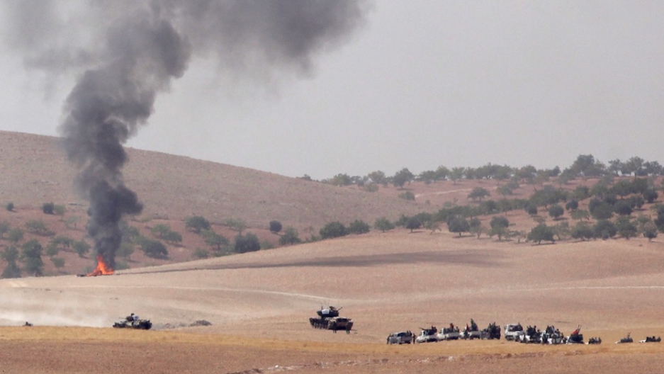 Turkish army tanks and Turkish-backed Syrian rebel fighters make their way in the Syrian border town of Jarablus on Aug. 24