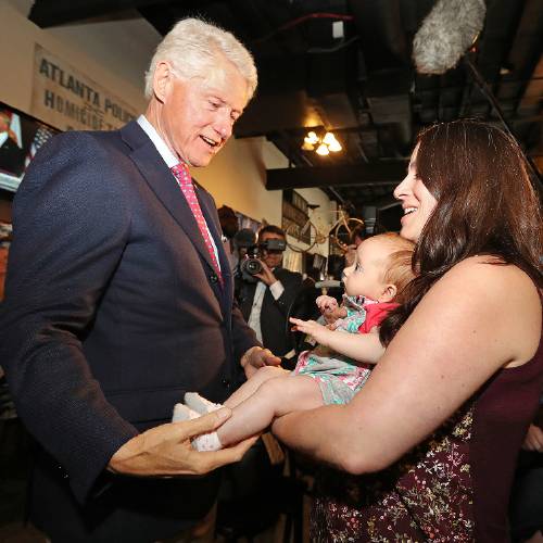 Bill Clinton left says hello to Megan Bartlett of Decatur Ga. and her 3-month-old daughter Hannah Rice as he works the crowd at historic Manuel's Tavern Wednesday Aug. 24 2016 during a stop in Atlanta. (Curtis Compt